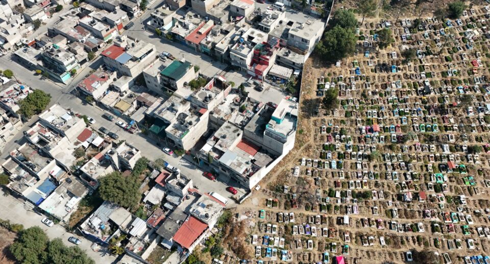 Luftaufnahme eines Wohnviertels neben einem Friedhof im Bundesstaat México
