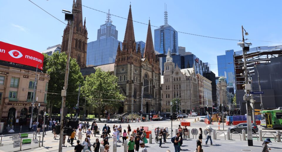 Lebendige Straßenszene in Melbourne mit St. Paul's Cathedral und moderner Skyline Australiens