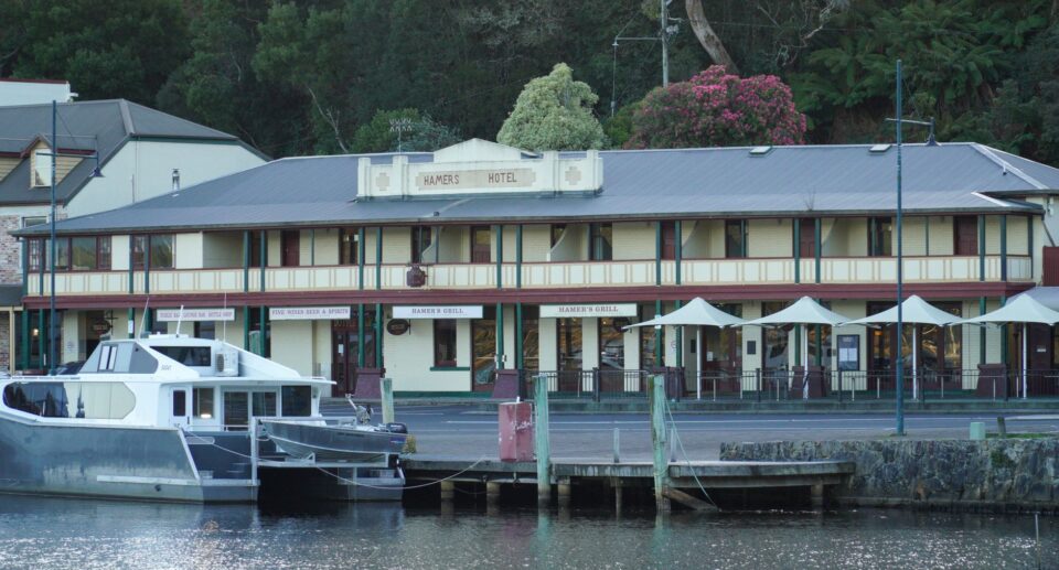 Hamers Hotel mit angedockten Booten am malerischen Hafen von Strahan, Tasmanien